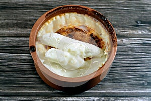 Rice pudding pottery casserole topped with milk cream, rice, corn flour, sugar, water or milk and other ingredients such as