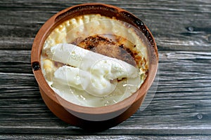 Rice pudding pottery casserole topped with milk cream, rice, corn flour, sugar, water or milk and other ingredients such as