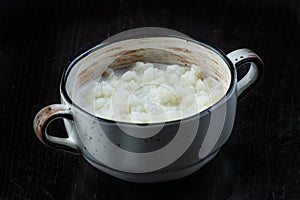 Rice pudding in white plate on dark background