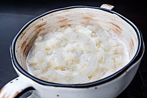 Rice pudding in white plate on dark background