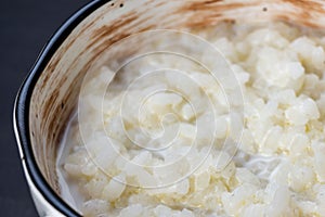 Rice pudding in white plate on dark background
