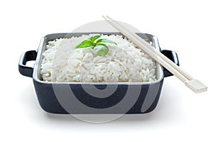 Rice served with basil in ceramic bowl with wooden chopsticks