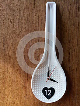 Rice spoon and clockwork on a wooden board