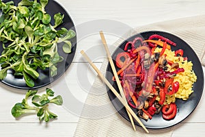 Rice and steamed vegetables on a black plate