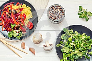 Rice and steamed vegetables on a black plate