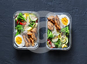 Rice, stewed vegetables, egg, teriyaki chicken - healthy balanced lunch box on a dark background, top view. Home food for office