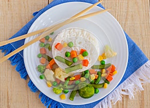 Rice with vegetables cooked on steam on a white plate