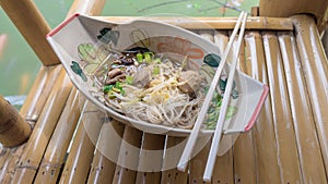 Rice vermicelli in thicken soup with sliced pork and pork ball on bamboo chair