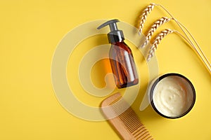 Rice, wheat, barley and oat shower gel, moisturizer cream, hair comb on yellow background. Natural herbal cosmetic products. Hair