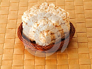Rice, wheat bread in the basket on brown background
