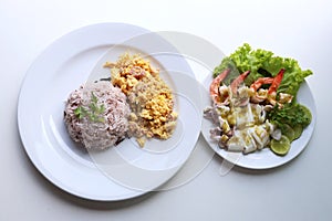 Riceberry with omelette With steamed lemon seafood served in a white round dish Put on the white table