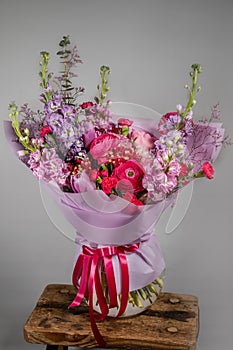 Rich bunch of pink and red flowers and lilac. Eustoma roses flowers, green leaf in glass vase. Fresh spring bouquet. Summer