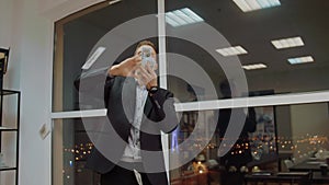 Rich business man throwing out money from stack on office window background