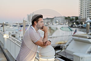 Rich businessman dreaming and thinking near the yacht. Portrait of confident man in modern big american city. Stylish