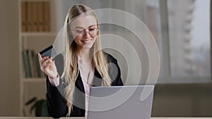 Rich caucasian business woman shopping online using laptop paying with credit bank card buy order booking remotely net