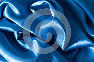 Rich classic blue satin folded fabric texture. Abstract background