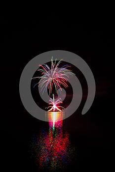 Rich and colorful fireworks over surface of Brno`s Dam with reflection on the surface of lake