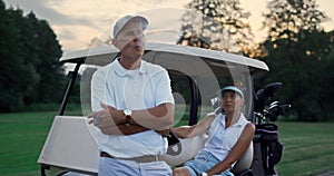 Rich couple enjoy golf evening on fairway. Family golfers relax summer holiday.