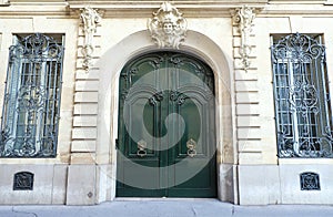 The rich decor decorates an entrance door of the old building of traditional architecture of in downtown, Paris.