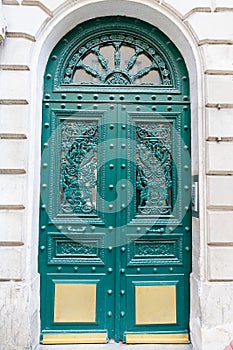 The rich decor decorates an entrance door of the old building of traditional architecture of in downtown, Paris.