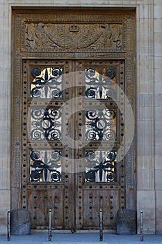 The rich decor decorates an entrance door of the old building of traditional architecture of in downtown, Paris.
