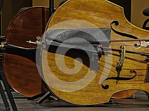 Bass fiddles at rest on the stage. Quiver holding bow. photo