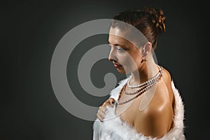 Rich lifestyle. Beautiful sexual woman wearing jewelery and white fur vest. Beauty, fashion
