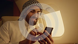 Rich man looking smartphone on travel closeup. Smiling arabian touching screen