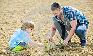 Rich natural soil. Eco farm. new life. soils and fertilizers. small boy child help father in farming. father and son