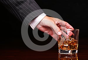 Rich and success business man holding in hand glass of whiskey
