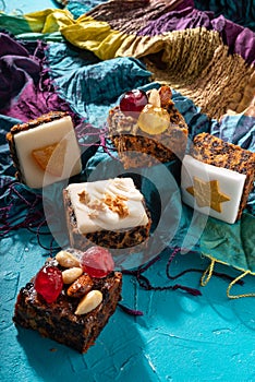 Rich sweet Christmas puddings loaded with dry fruits, nuts and spices on vibrant eastern background