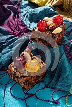 Rich sweet Christmas puddings loaded with dry fruits, nuts and spices on vibrant eastern background