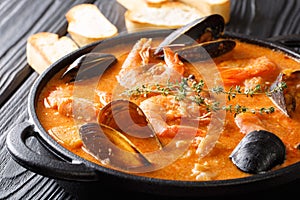 The rich taste of seafood Suquet de Peix soup with potatoes, her photo