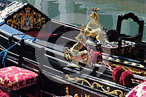 Richly decorated gondolas with golden seahorses in a water canal in Venice