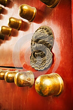 Richly decorated red wooden door with decoration in the Forbidden City, Beijing, China.