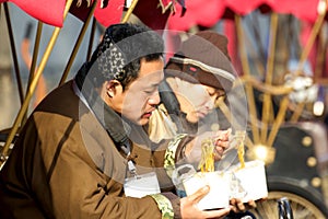 Rickshaw drivers eating instant noodles for lunch in the winter in a tourist spot of Beijing, China