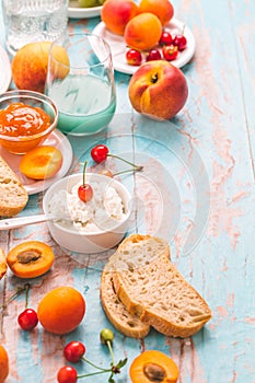 Ricotta cheese with peach and apricot jam, ciabatta, fruits and smoothie