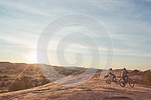 Ride long, ride strong. Full length shot of two young male athletes mountain biking in the wilderness.