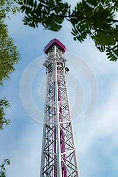 Ride tower in motion in amusement park on blue sky background