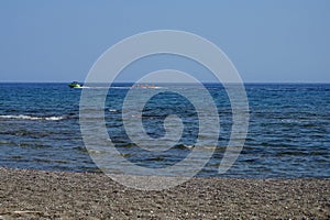 Ride of vacationers on an inflatable water banana, water sleigh, is a classic entertainment for a seaside resort. Pefki, Rhodes