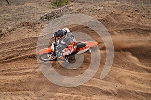 Rider at the beginning of rut turning sandy MX track