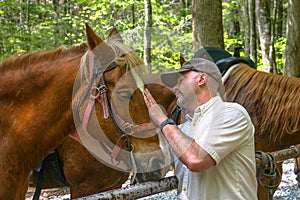 Rider caring for his horse on the trail.