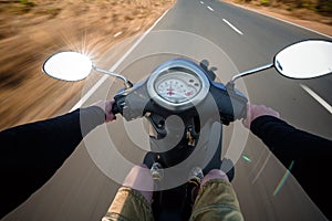 Rider driving scooter on an asphalt road. Motion blurred backgro