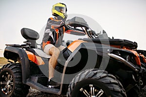 Rider in helmet on quad bike, front view, closeup