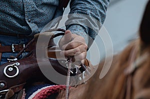 Rider holds onto reins of his horse photo