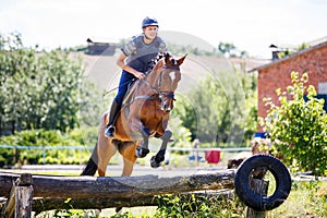 Rider jumps horse over log on cross-country course