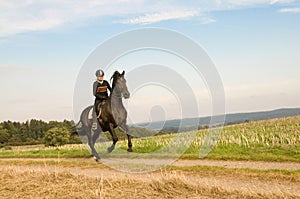 Rider rides at a gallop across the field.