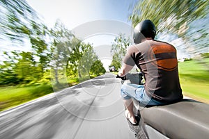 Rider on scooter motorcycle in parkway