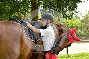 Rider tacking up her horse