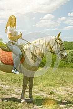 the rider on the white horse. Young horsewoman riding on white horse, outdoors view. girl on white horse runs free
